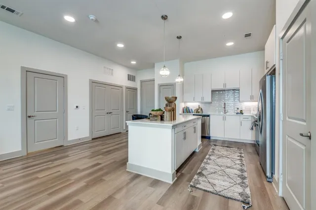 a kitchen with white cabinets and stainless steel appliances
