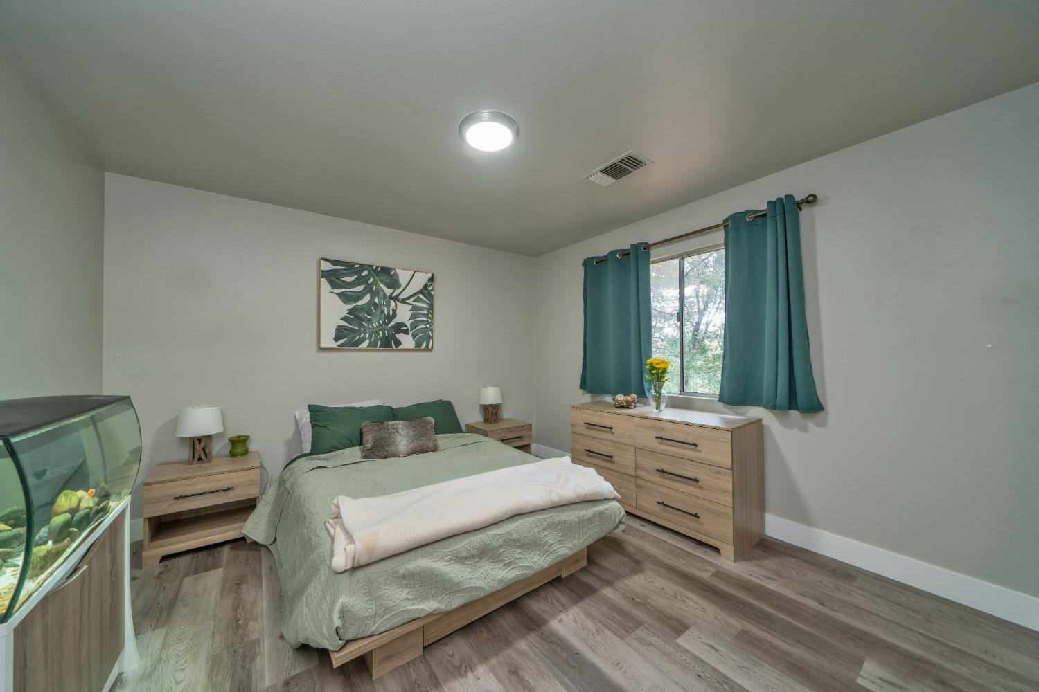 5781 Sly Park Road Pollock Pines, CA 95726 - Photo 12 of 40 a bedroom with a bed a dresser next to a window