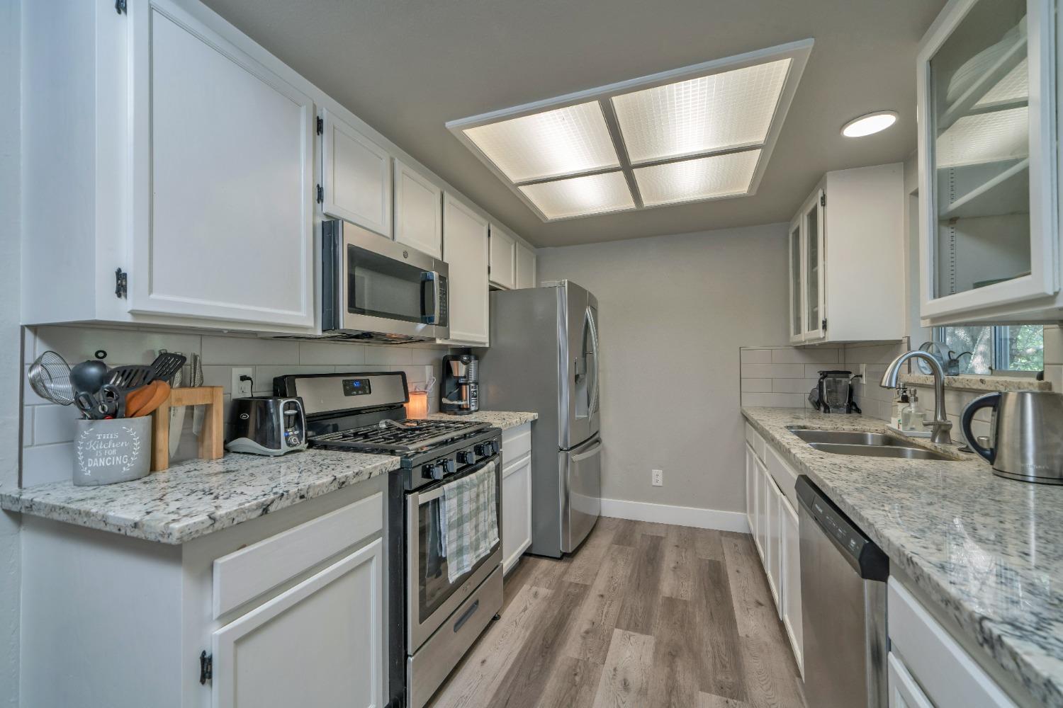 5781 Sly Park Road Pollock Pines, CA 95726 - Photo 15 of 40 a kitchen with stainless steel appliances granite countertop a sink stove microwave and refrigerator