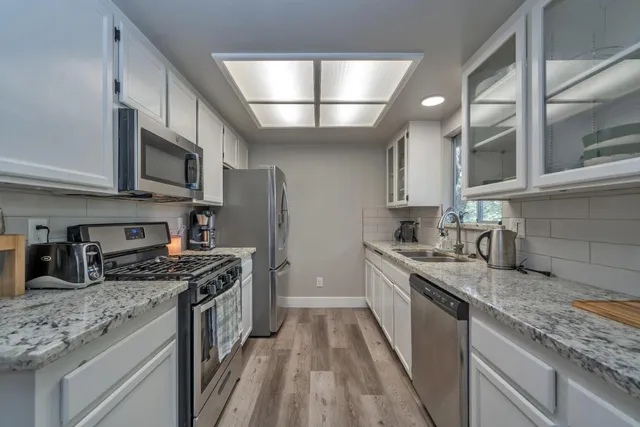 a kitchen with stainless steel appliances granite countertop a sink stove microwave and cabinets