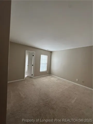 an empty room with windows and fireplace
