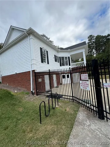 a view of swimming pool with lawn chairs and wooden fence
