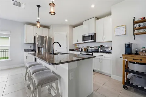 a kitchen with stainless steel appliances granite countertop a sink a stove and a refrigerator