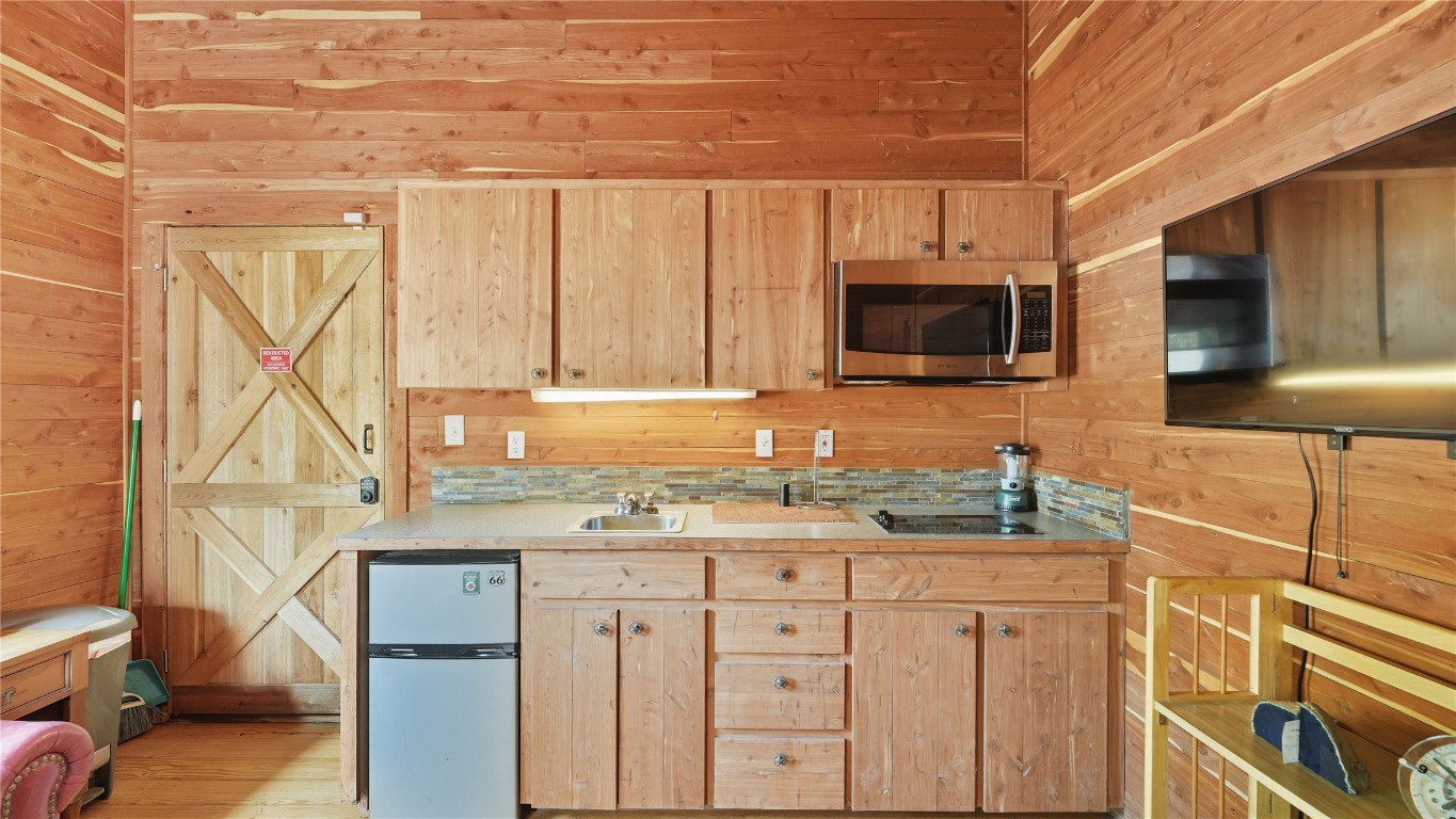 2656 River Bend Road Smithville, TX 78957 - Photo 25 of 40 a kitchen with stainless steel appliances a stove microwave and cabinets