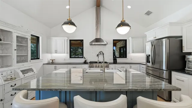 a kitchen with stainless steel appliances a stove a sink and a refrigerator