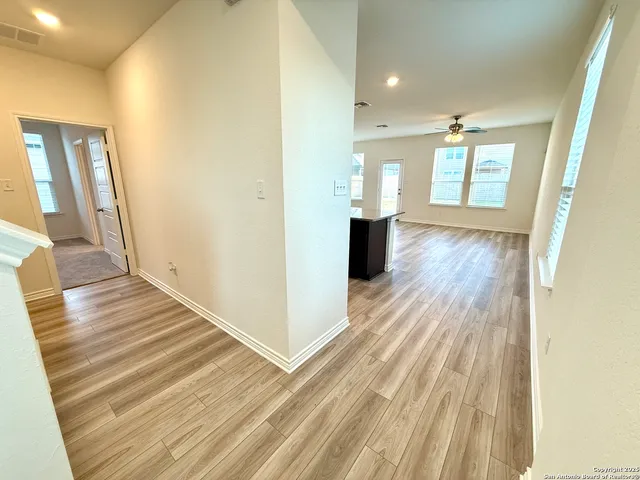 a view of a hallway with wooden floor and staircase