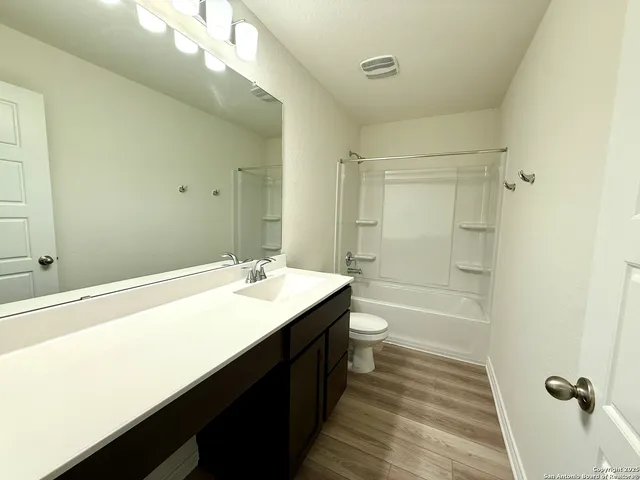 an empty room with a window and a ceiling fan