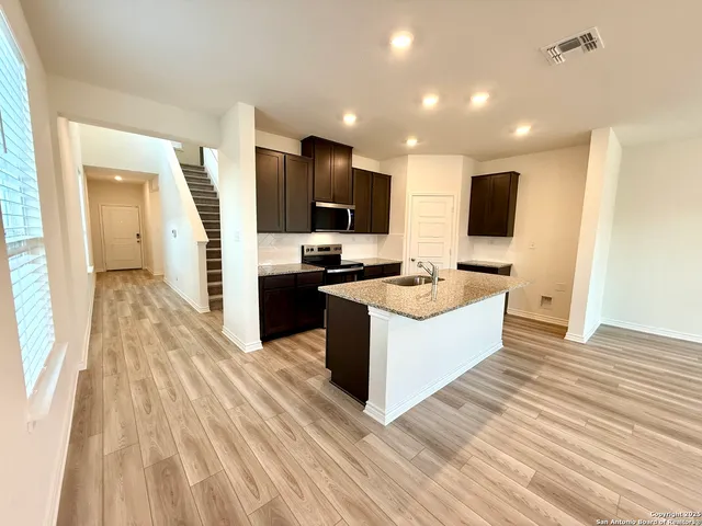 a large kitchen with kitchen island a sink dishwasher a stove and a refrigerator