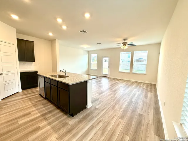 a living room with stainless steel appliances kitchen island granite countertop a large counter top and a flat screen tv