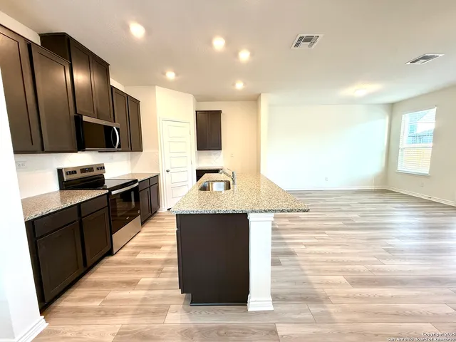 a large kitchen with stainless steel appliances kitchen island granite countertop a large counter top and stove