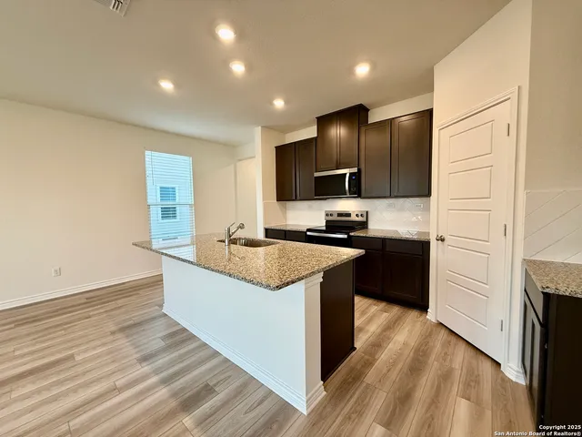 a kitchen with granite countertop a sink and a stove top oven