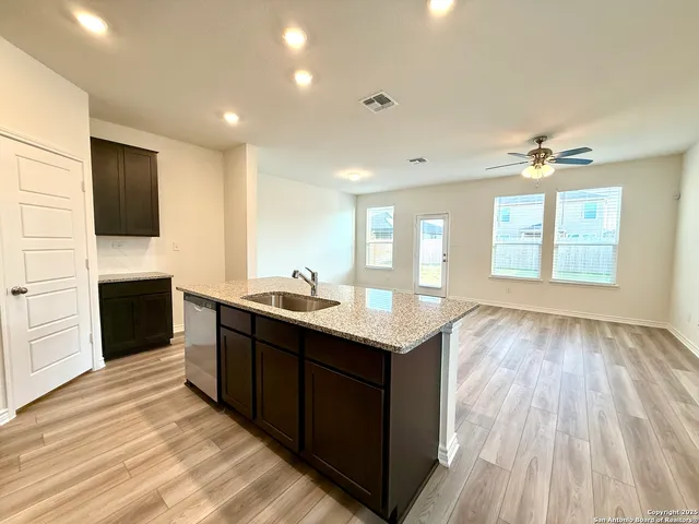a kitchen with stainless steel appliances granite countertop a sink stove and cabinets