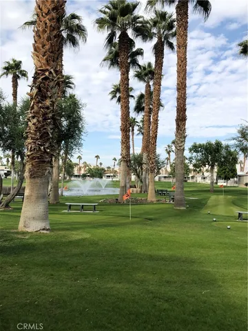 a green field with trees in the background
