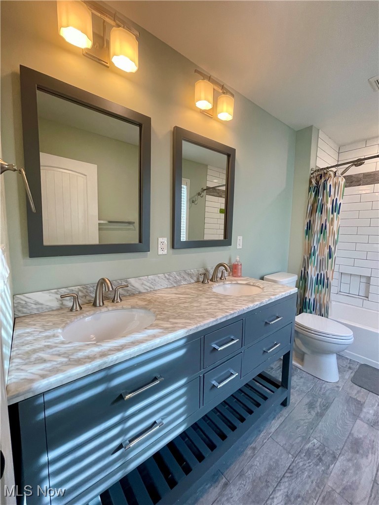 1544 Edgefield Road Lyndhurst, OH 44124 - Photo 35 of 36 Bathroom featuring double vanity, shower / bath combo with shower curtain, and light wood finished floors