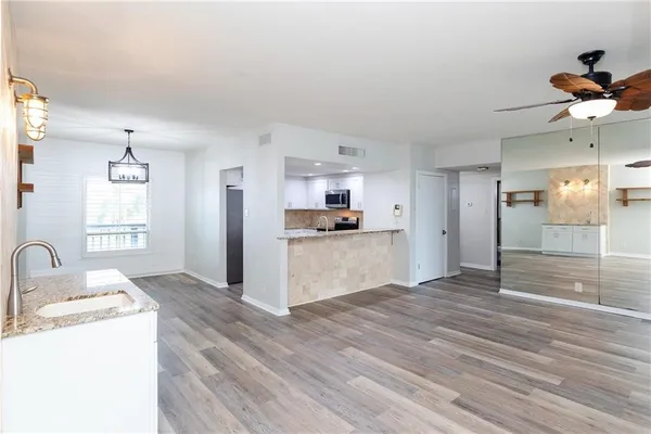 a kitchen with stainless steel appliances granite countertop a refrigerator and a stove top oven