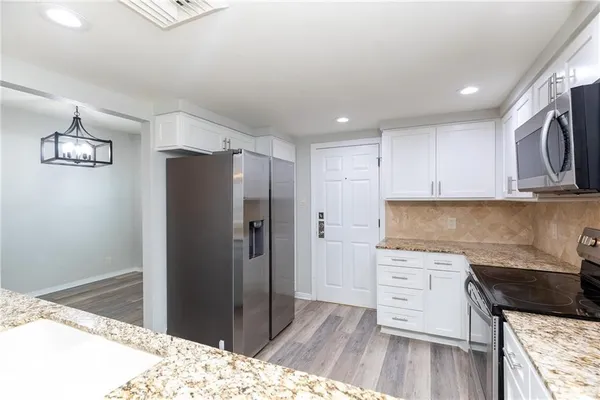 a kitchen with granite countertop a sink stove and refrigerator