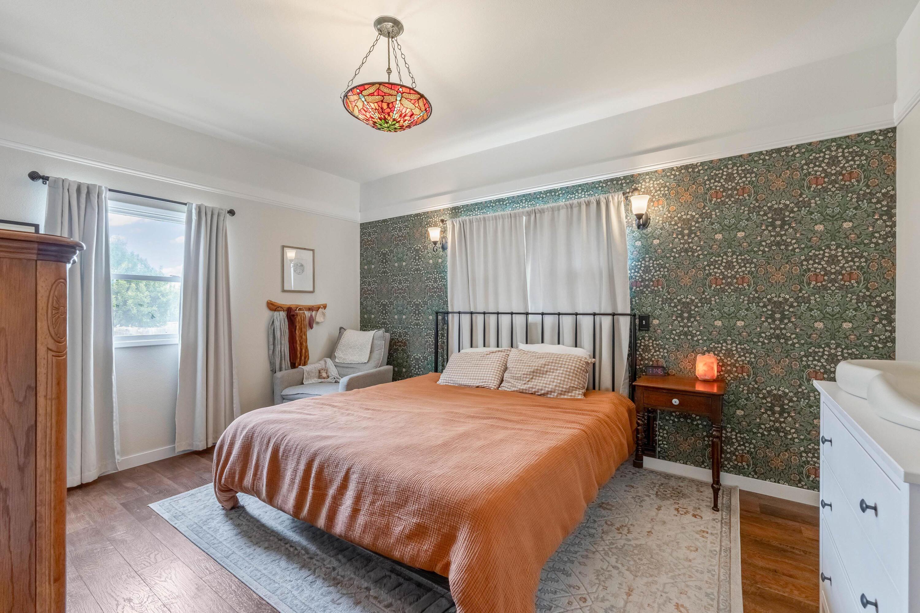 496 Southwest 2nd Street Madras, OR 97741 - Photo 13 of 37 a bedroom with a bed and a chandelier