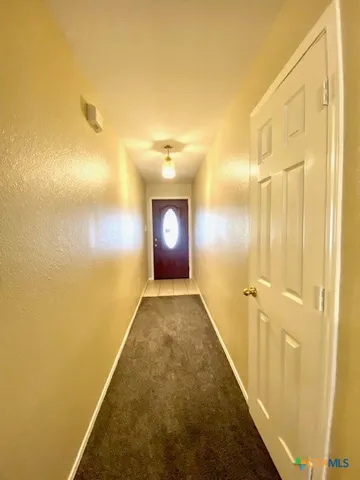 a view of hallway with a bathroom