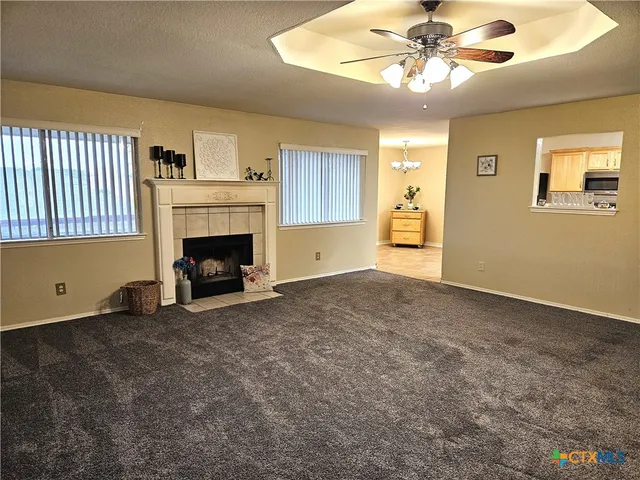 a view of an empty room with window and fireplace