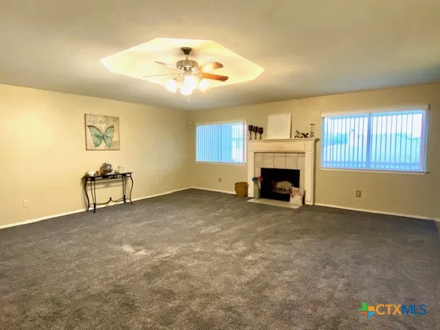 a view of an empty room with a fireplace and a window