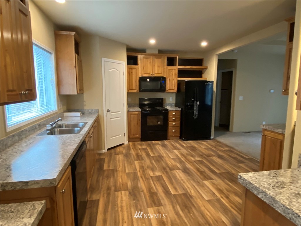 156 Nelson Road Winlock, WA 98596 - Photo 4 of 19 a kitchen with kitchen island granite countertop a refrigerator stove top oven and sink