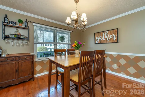 a view of a dining room with furniture a chandelier and wooden floor