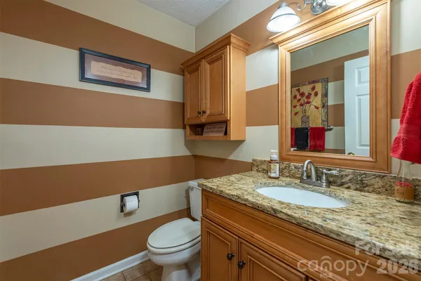a bathroom with a granite countertop sink and a toilet