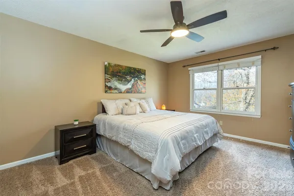 a spacious bedroom with a bed and a ceiling fan