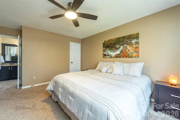 a bedroom with a bed and a painting on the wall