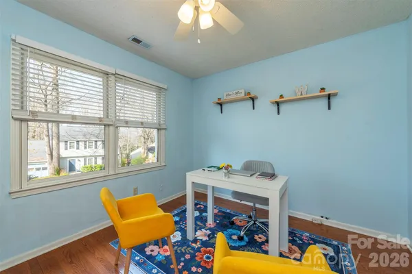 a view of a workspace with furniture and a window