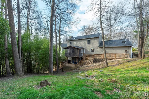 a view of a house with backyard and a tree