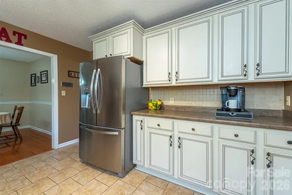 a kitchen with granite countertop a refrigerator and cabinets