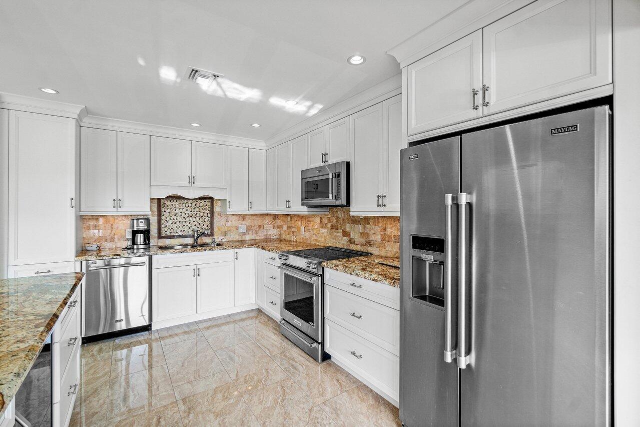 11110 Quail Covey Road, Unit MOCKINGBIRD Boynton Beach, FL 33436 - Photo 7 of 45 a kitchen with granite countertop a refrigerator stove top oven and sink