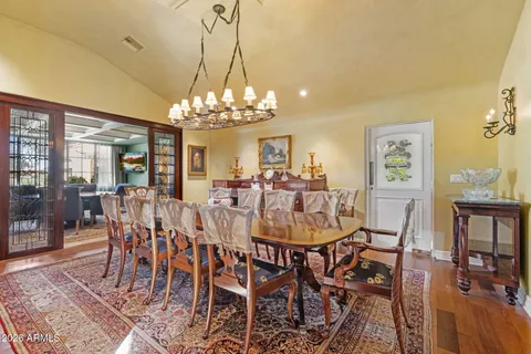 a view of a dining room with furniture a chandelier and wooden floor