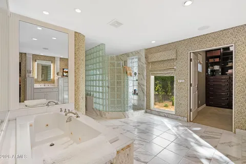 a bathroom with a tub shower and sink