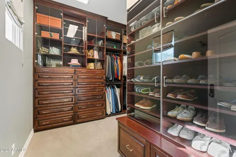a view of walk in closet with clothes and shoes