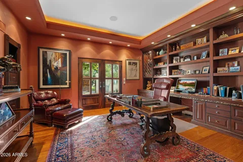 a living room with furniture a bookshelf and a large window