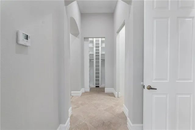 an empty room with wooden floor cabinet and windows