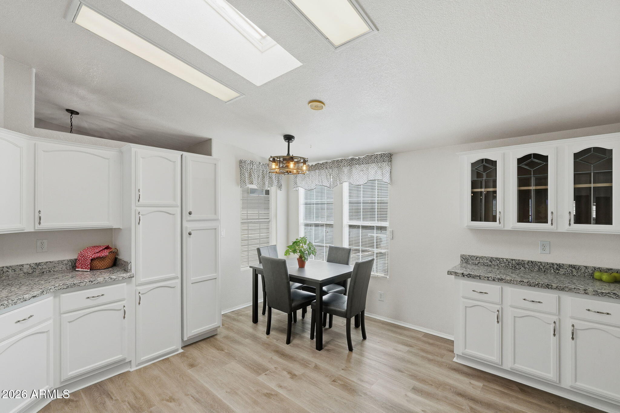 3301 South Goldfield Road, Unit 1015 Apache Junction, AZ 85119 - Photo 10 of 34 a open kitchen with granite countertop white cabinets dining table and chairs
