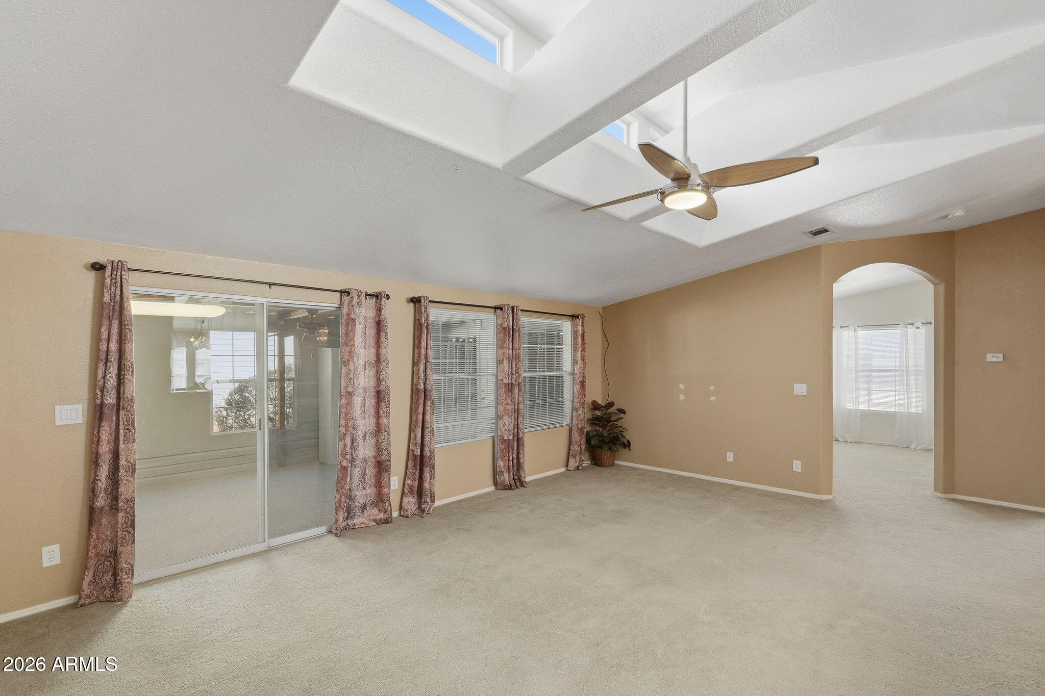 3301 South Goldfield Road, Unit 1015 Apache Junction, AZ 85119 - Photo 13 of 34 an empty room with chandelier fan and windows