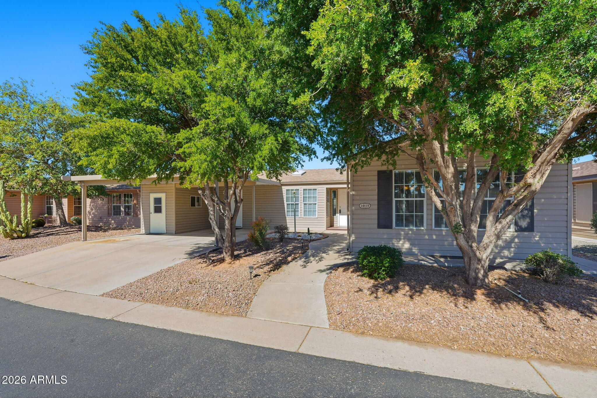 3301 South Goldfield Road, Unit 1015 Apache Junction, AZ 85119 - Photo 2 of 34 a front view of a house with a yard and garage