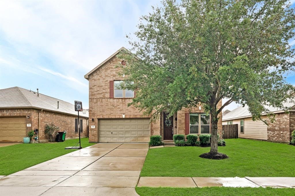 a front view of a house with a yard and garage