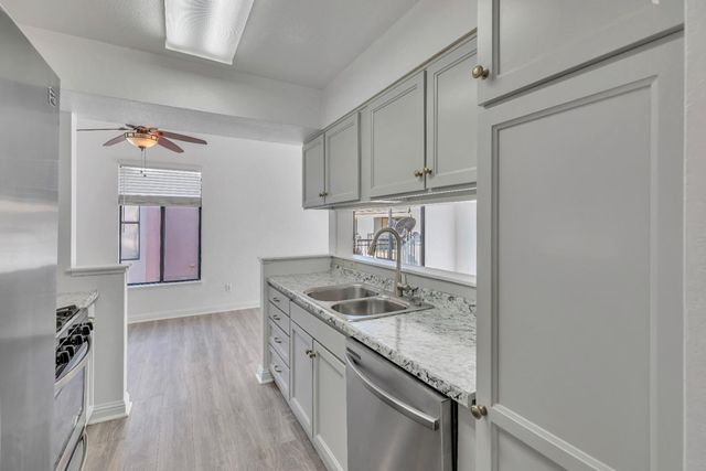 a kitchen with granite countertop a sink and a stove top oven
