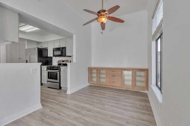 a kitchen with stainless steel appliances a stove top oven a refrigerator cabinets and wooden floor