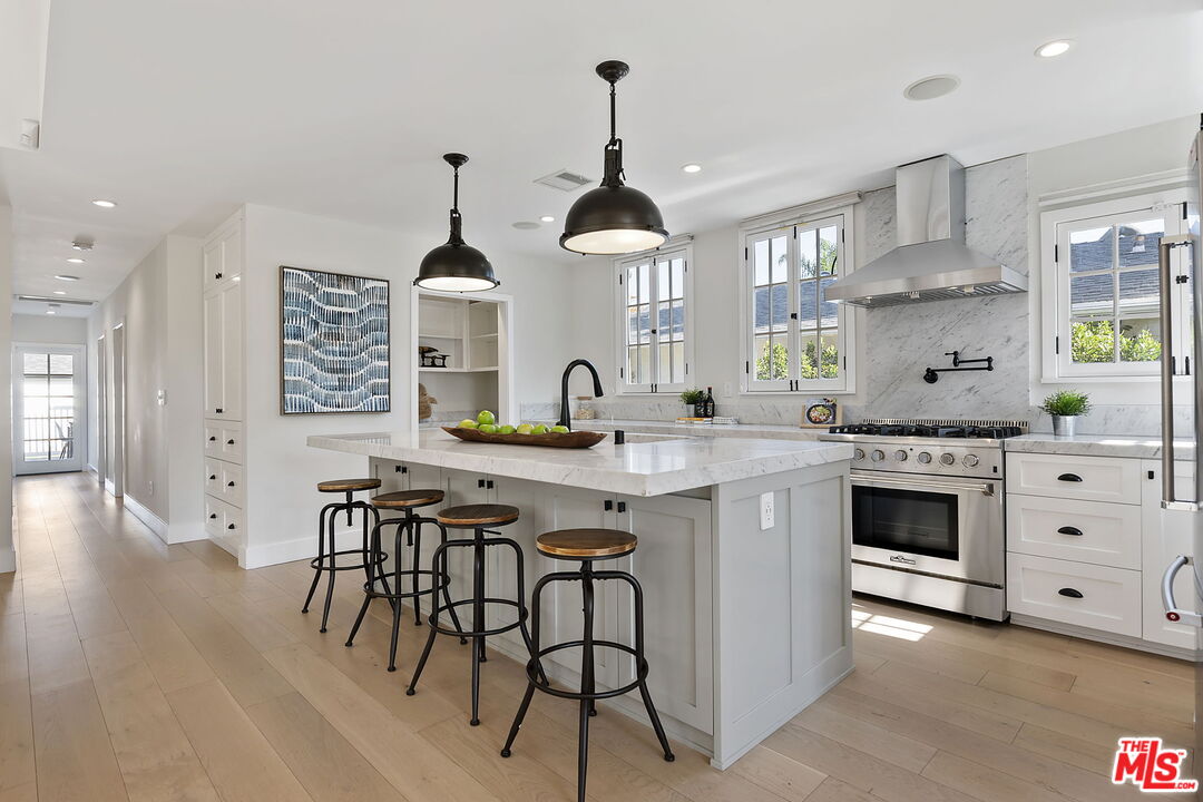 6507 West Olympic Boulevard Los Angeles, CA 90048 - Photo 15 of 50 a kitchen with stainless steel appliances a stove a sink and a wooden floors