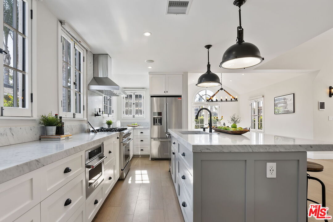 6507 West Olympic Boulevard Los Angeles, CA 90048 - Photo 17 of 50 a kitchen with white cabinets and a stove