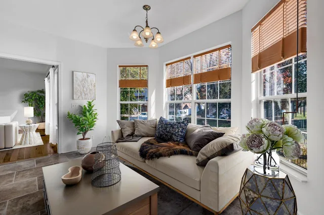a living room with furniture a flat screen tv and a large window