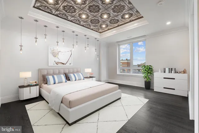 a bedroom with a large bed and a chandelier