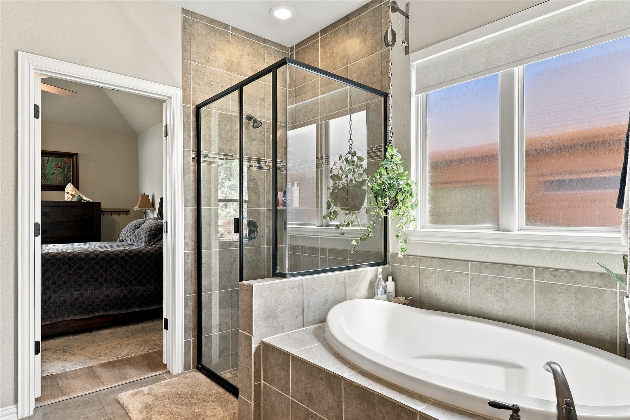 320 Fort Cobb Way Georgetown, TX 78628 - Photo 14 of 37 A deep soaking tub sits adjacent to a glass-enclosed shower featuring tiled walls.
