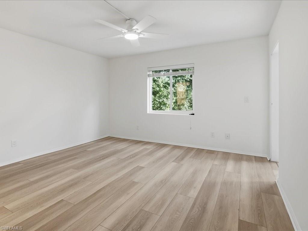 1001 Foxfire Lane, Unit 204 Naples, FL 34104 - Photo 13 of 35 wooden floor in an empty room with a window